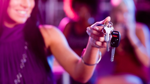 Woman at a party handing off her keys. Designated Driver.
