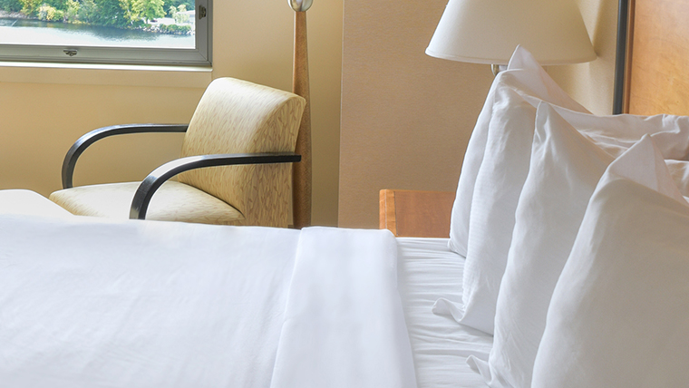 Deluxe hotel room with white bedding overlooking the Penobscot River.