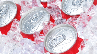 Five red soda cans in ice. 