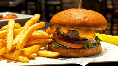 Classic cheeseburger with lettuce, tomato, and onion with a side of fries in Hops House 99 restaurant.