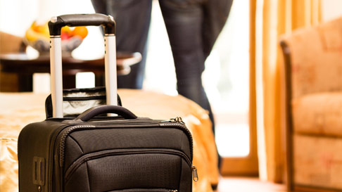 suitcase by hotel bed