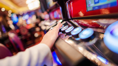 woman pushing slot machine button